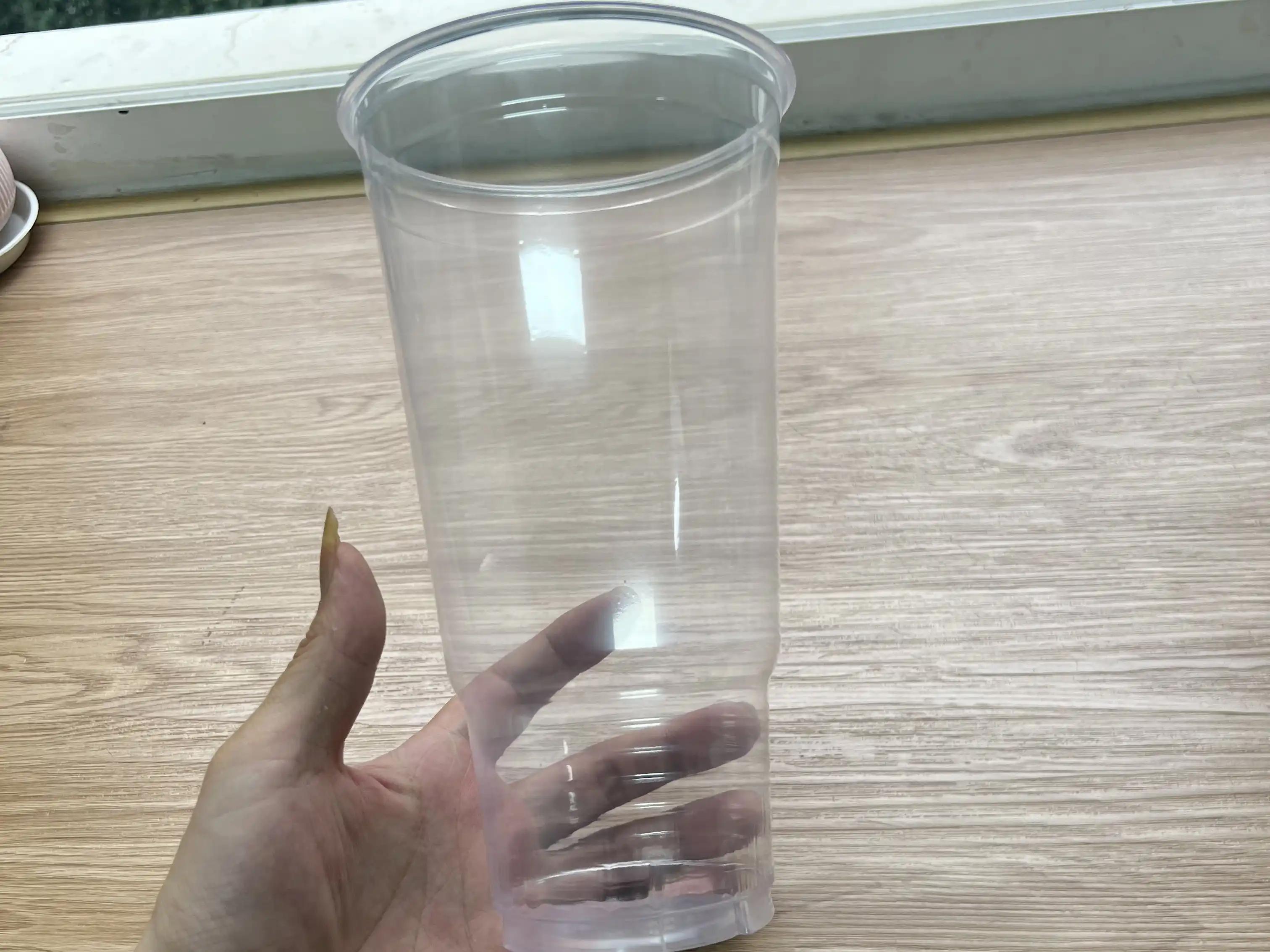 44oz jumbo clear PET cup held for size and transparency comparison